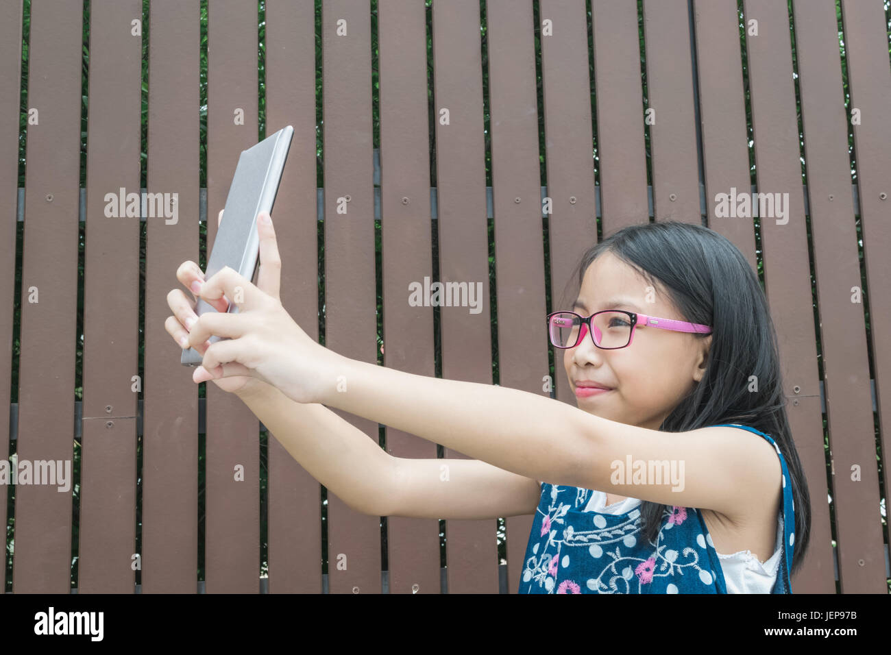 Schöne Mädchen mit Tablet zum Lernen im Park. Konzept-Technikunterricht. Stockfoto