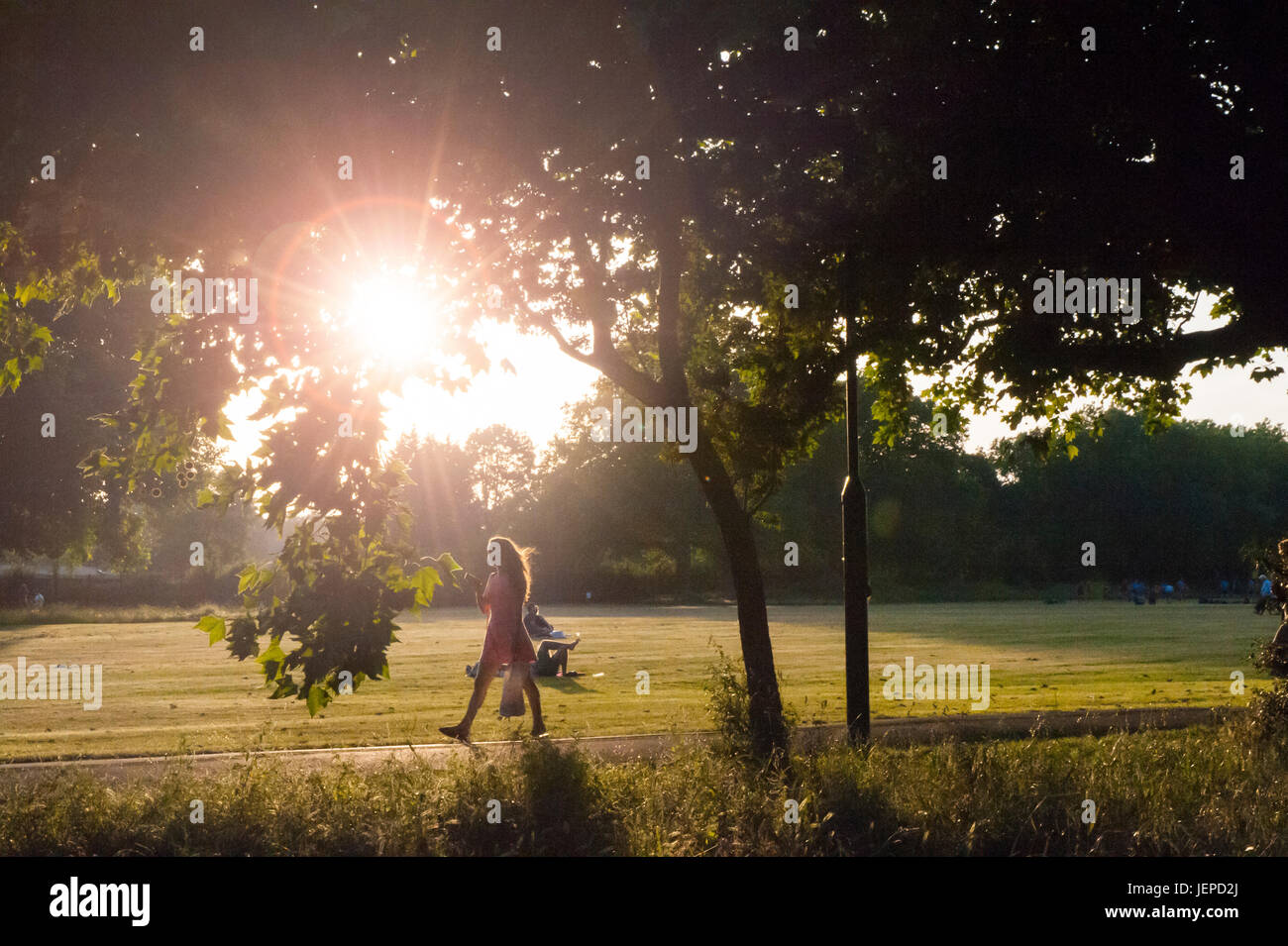 Ein Mädchen in ein hübsches Kleid geht in einem Londoner park Stockfoto