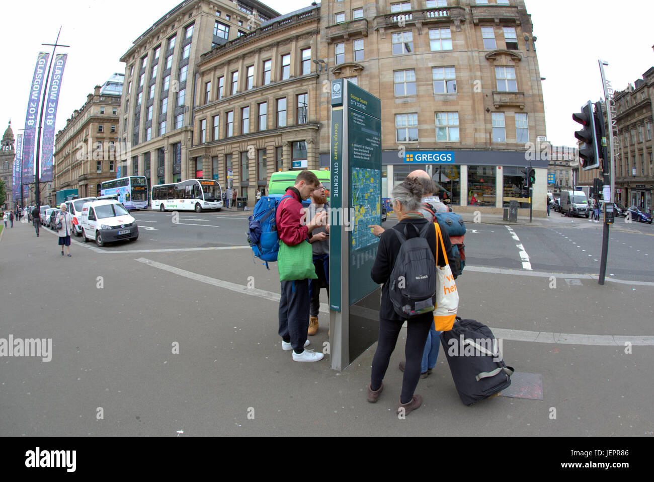 Amerikanische Touristen mit Gepäck auf den Straßen von Glasgow Blick auf Stadtplan Stadtführer Stockfoto