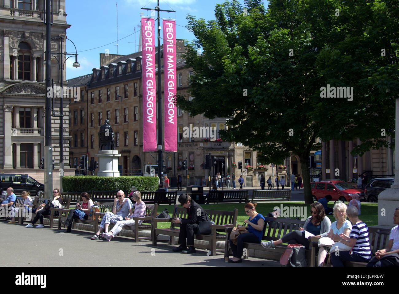 Wetter im Sommer kehrt zurück und Menschen genießen Sie den Sommer auf den Straßen, George Square, Schottland-Touristen fängt einige aus dem sonnigen Wetter Stockfoto