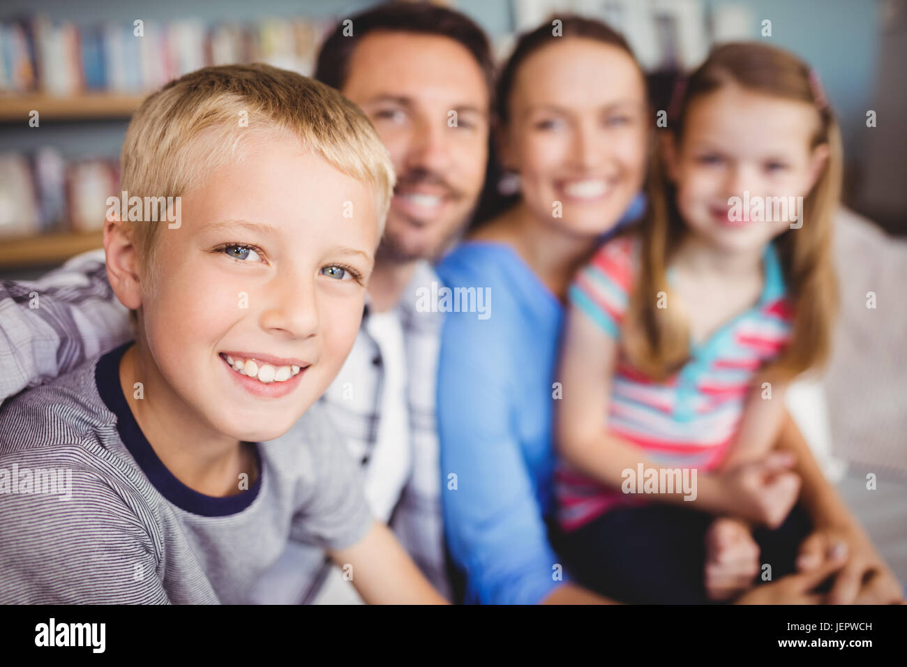 Fröhlicher Junge mit Familie auf sofa Stockfoto