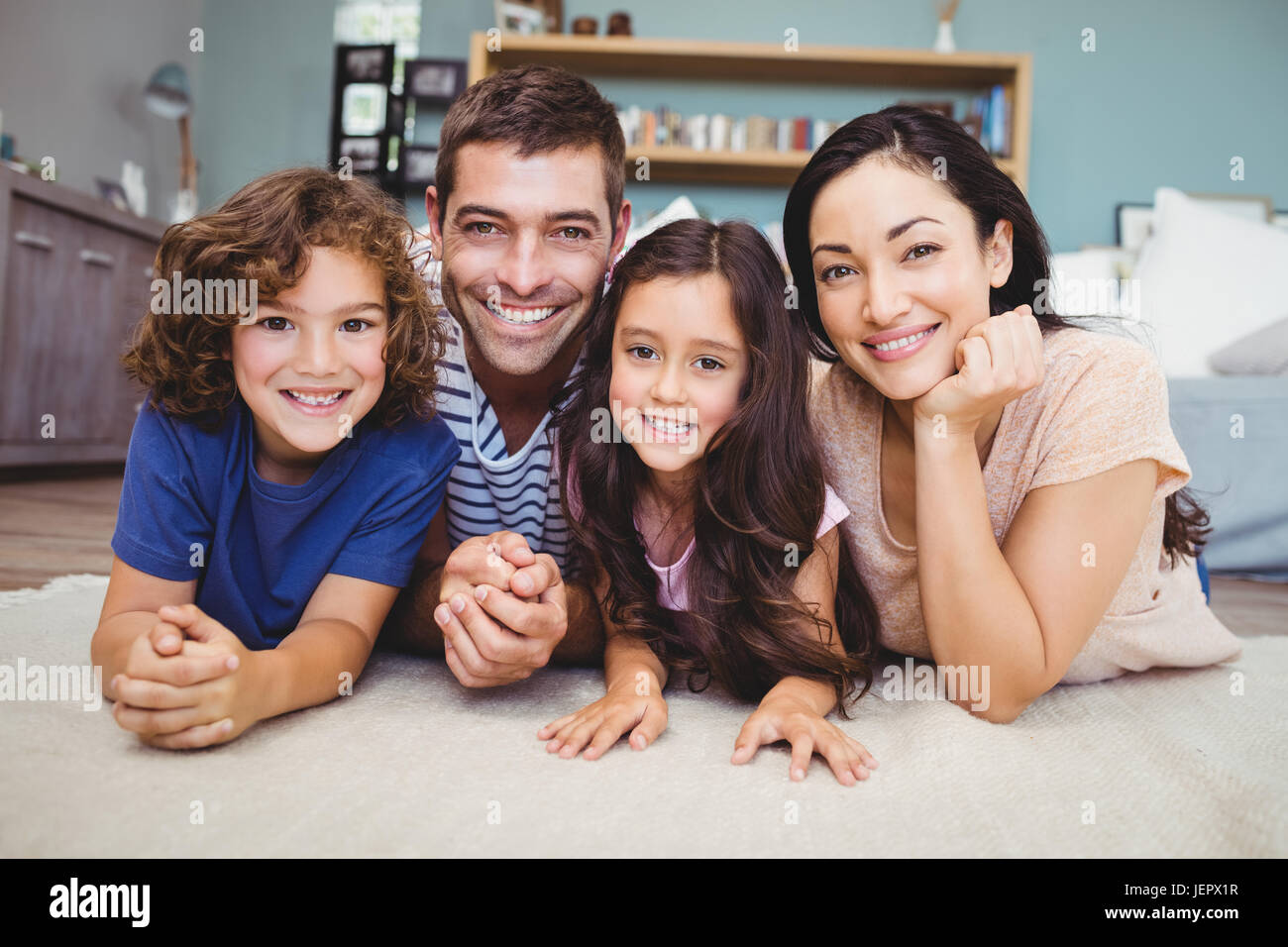 Porträt der glückliche Familie liegen auf Teppich Stockfoto