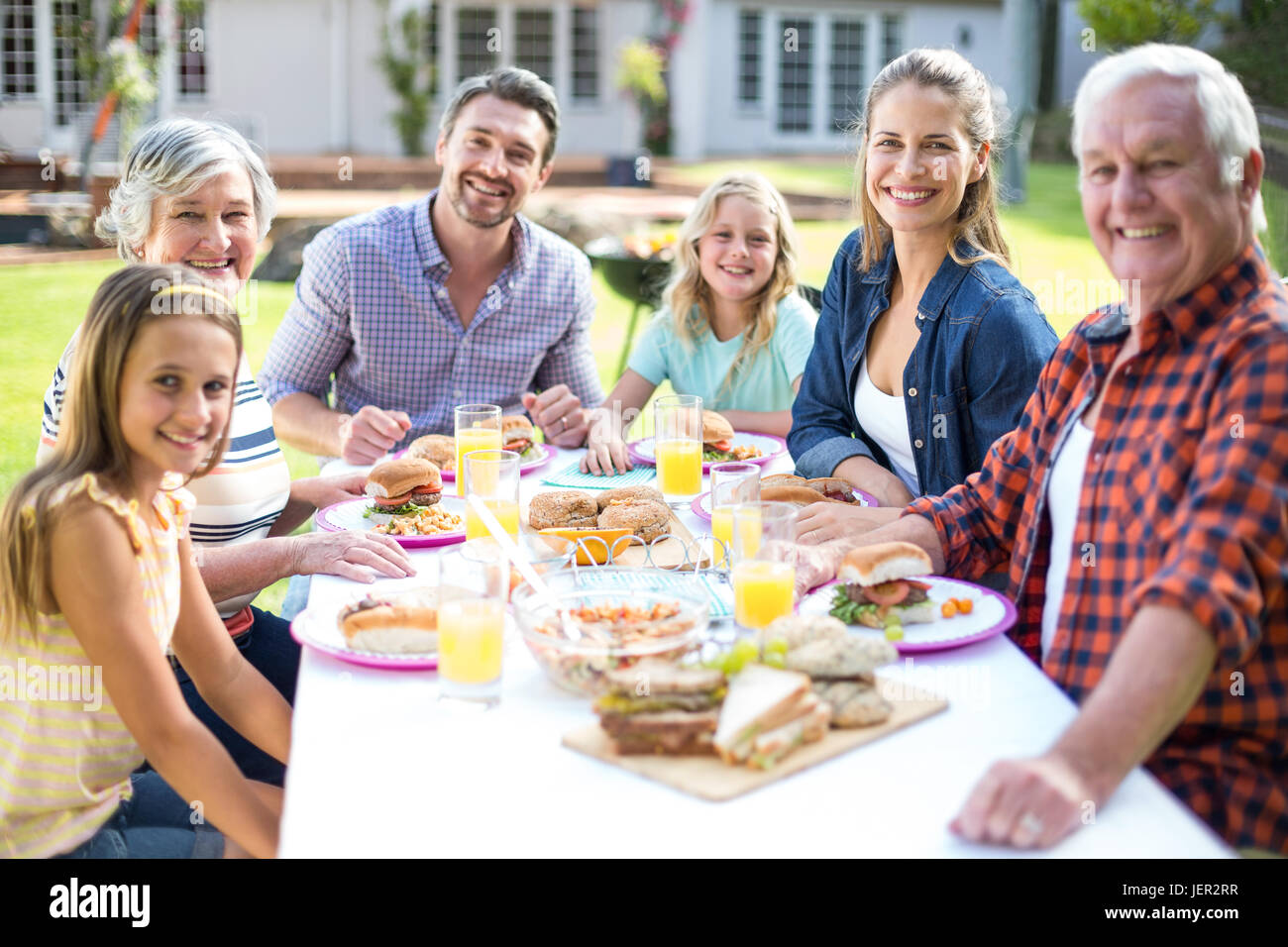 Porträt der fröhlichen Familie am Tisch sitzen Stockfoto