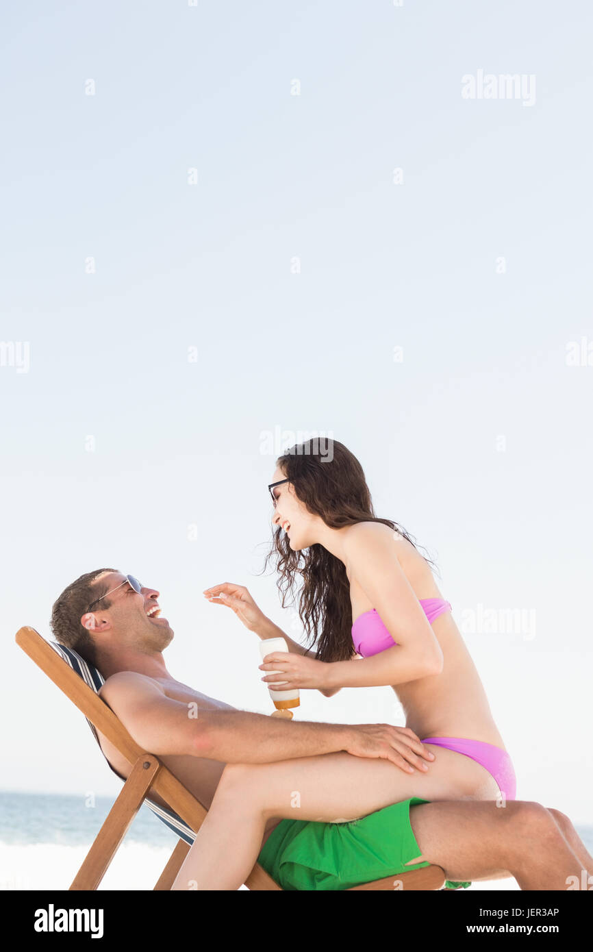Auftragen von Sonnencreme auf Freund Freundin Stockfoto