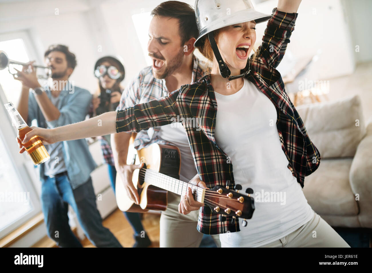 Fröhliche junge Freunde Party zusammen und spielen von Instrumenten Stockfoto