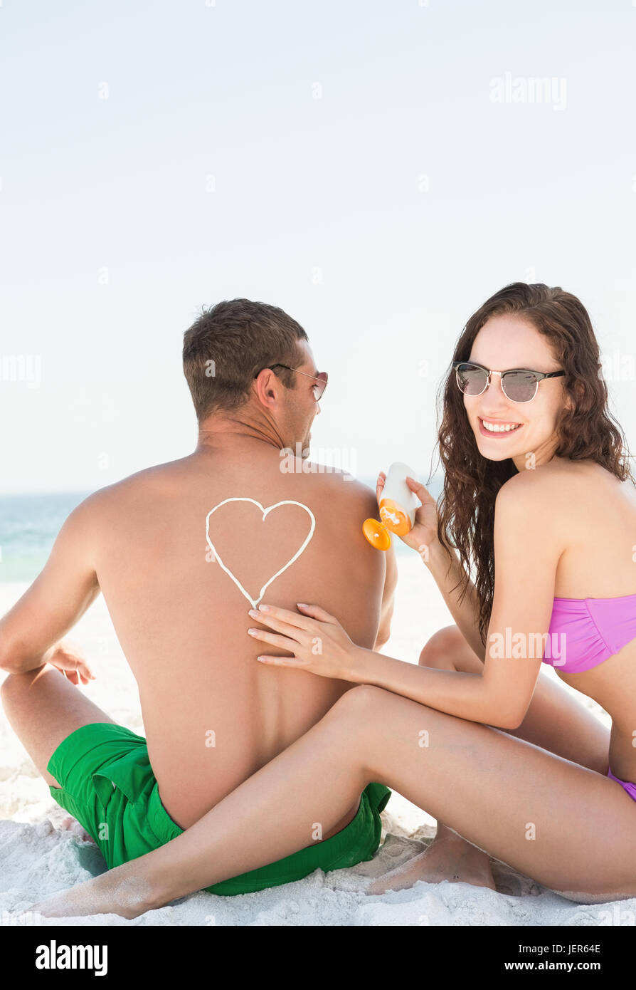 Auftragen von Sonnencreme auf Freund Freundin Stockfoto