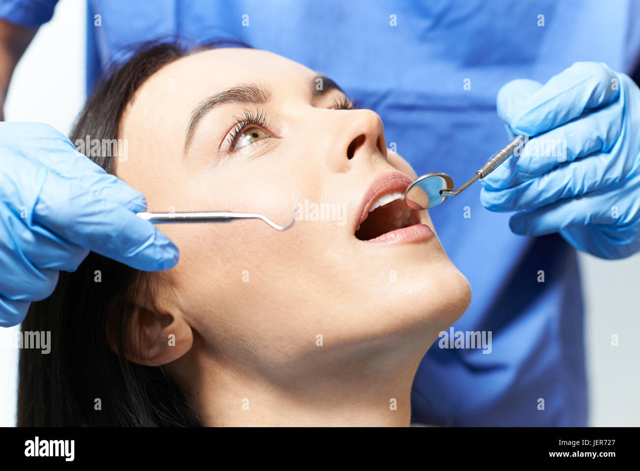 Junge Frau mit Check Up und zahnärztliche Untersuchung beim Zahnarzt Stockfoto