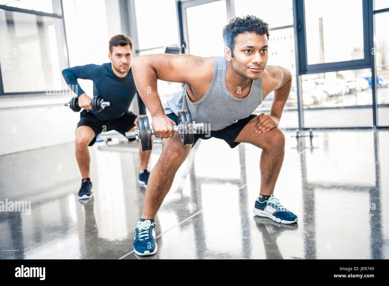 junge Männer Training mit Hanteln im Fitnessstudio Stockfoto