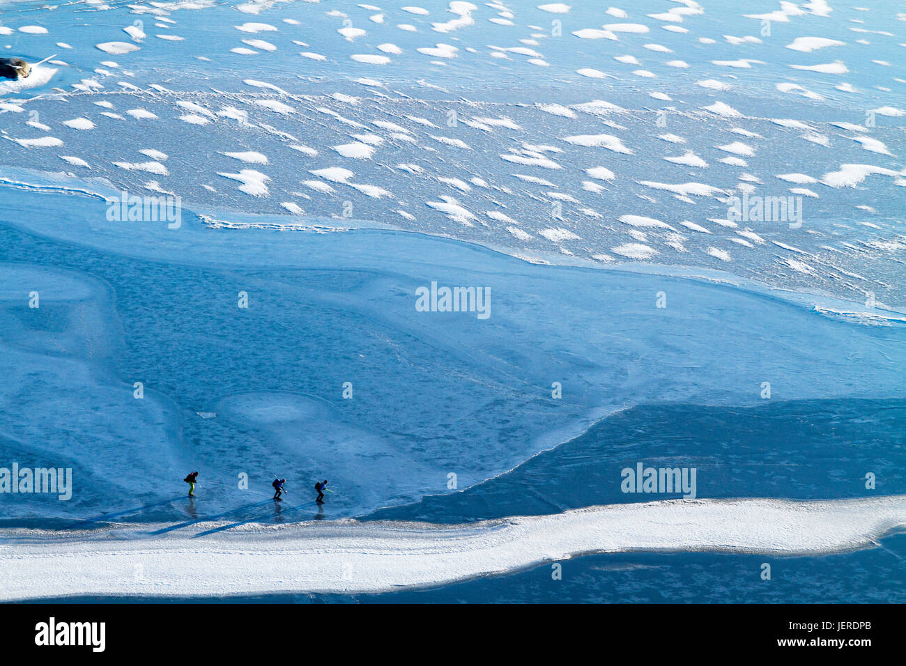 Schlittschuhlaufen auf dem zugefrorenen Wasser Menschen Stockfoto