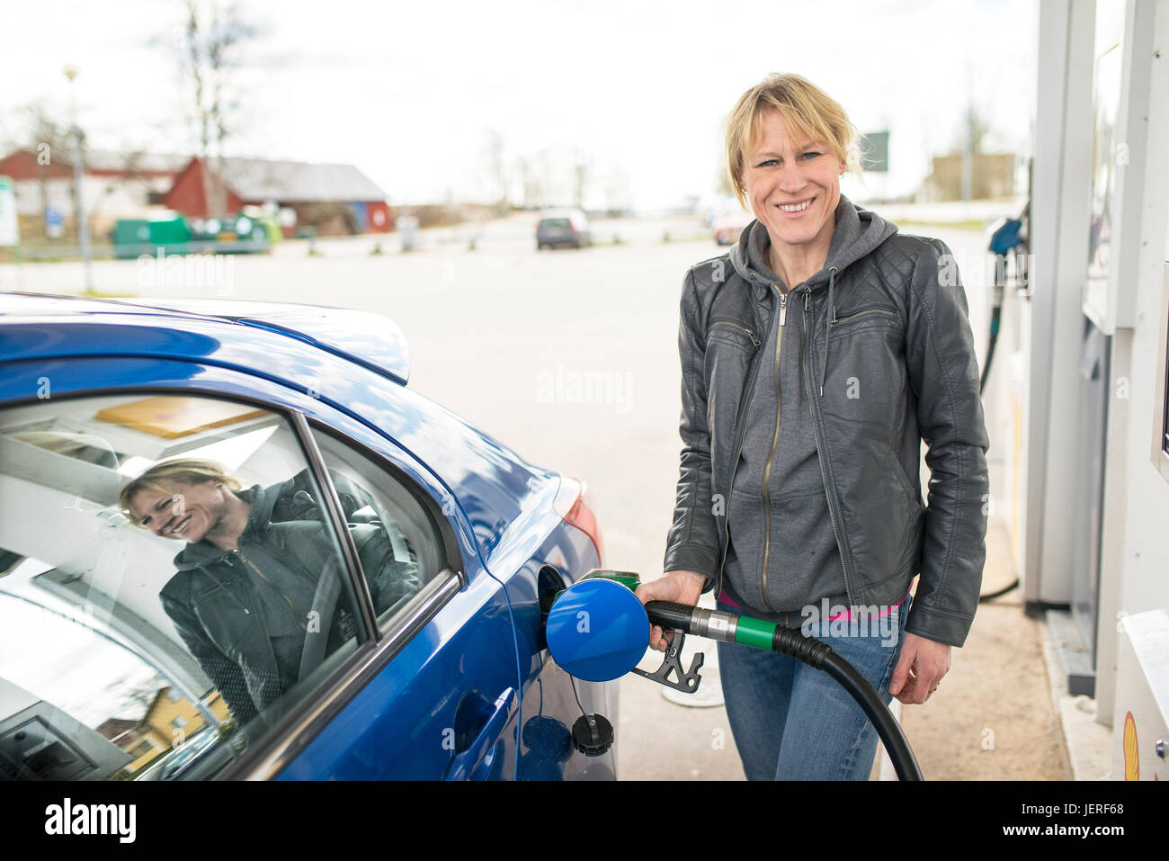 Lächelnde Frau tanken Auto Stockfoto