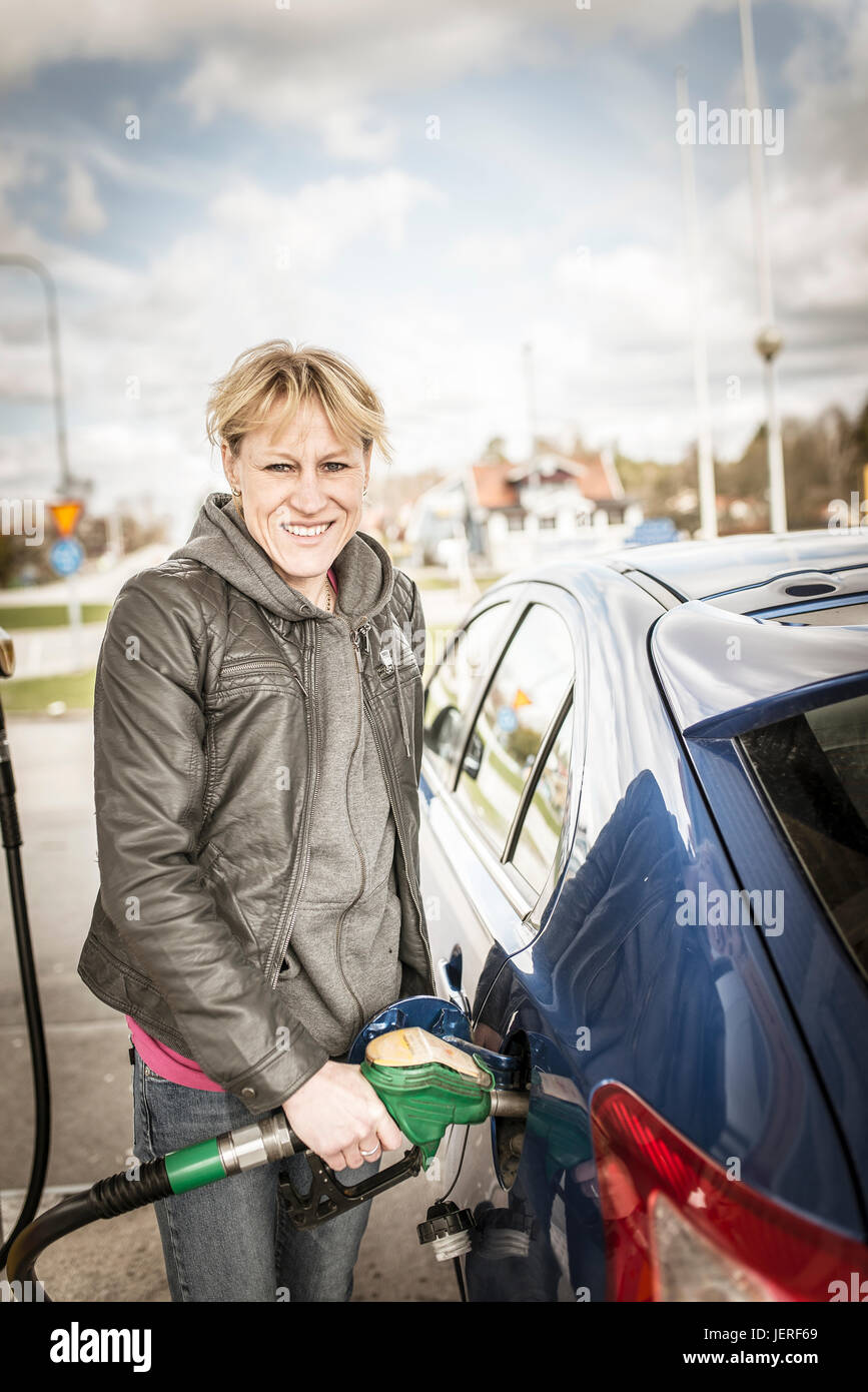 Lächelnde Frau tanken Auto Stockfoto