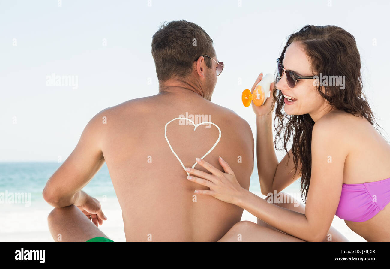 Auftragen von Sonnencreme auf Freund Freundin Stockfoto