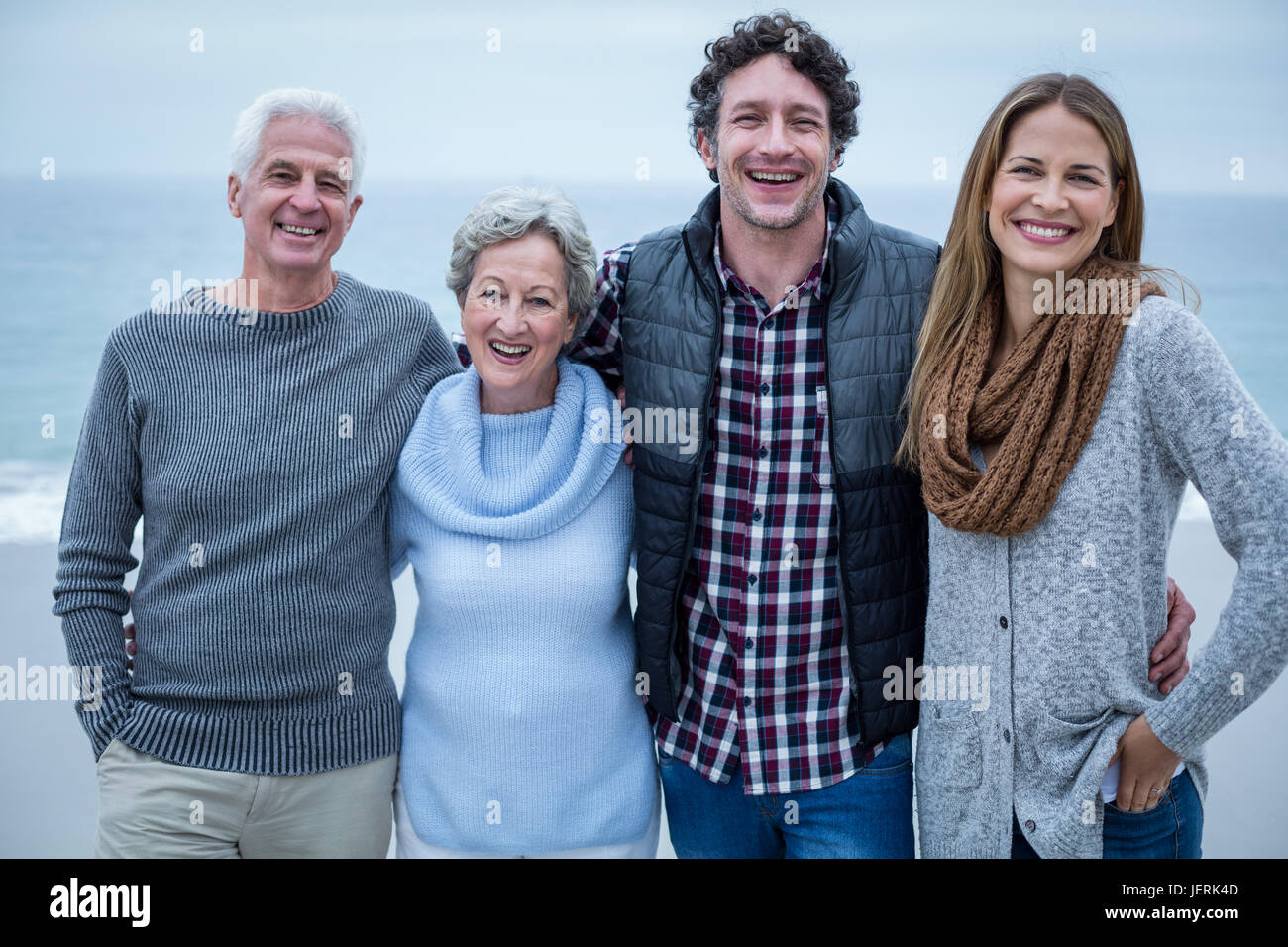Fröhliche Familie stehen am Ufer am Strand Stockfoto