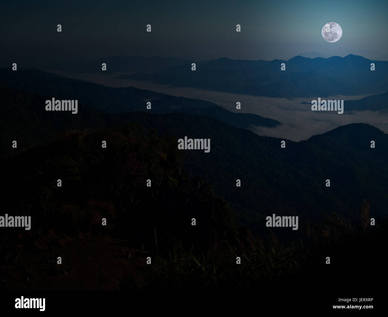 Berg und Nebel mit Foull Mond um Mitternacht. Stockfoto