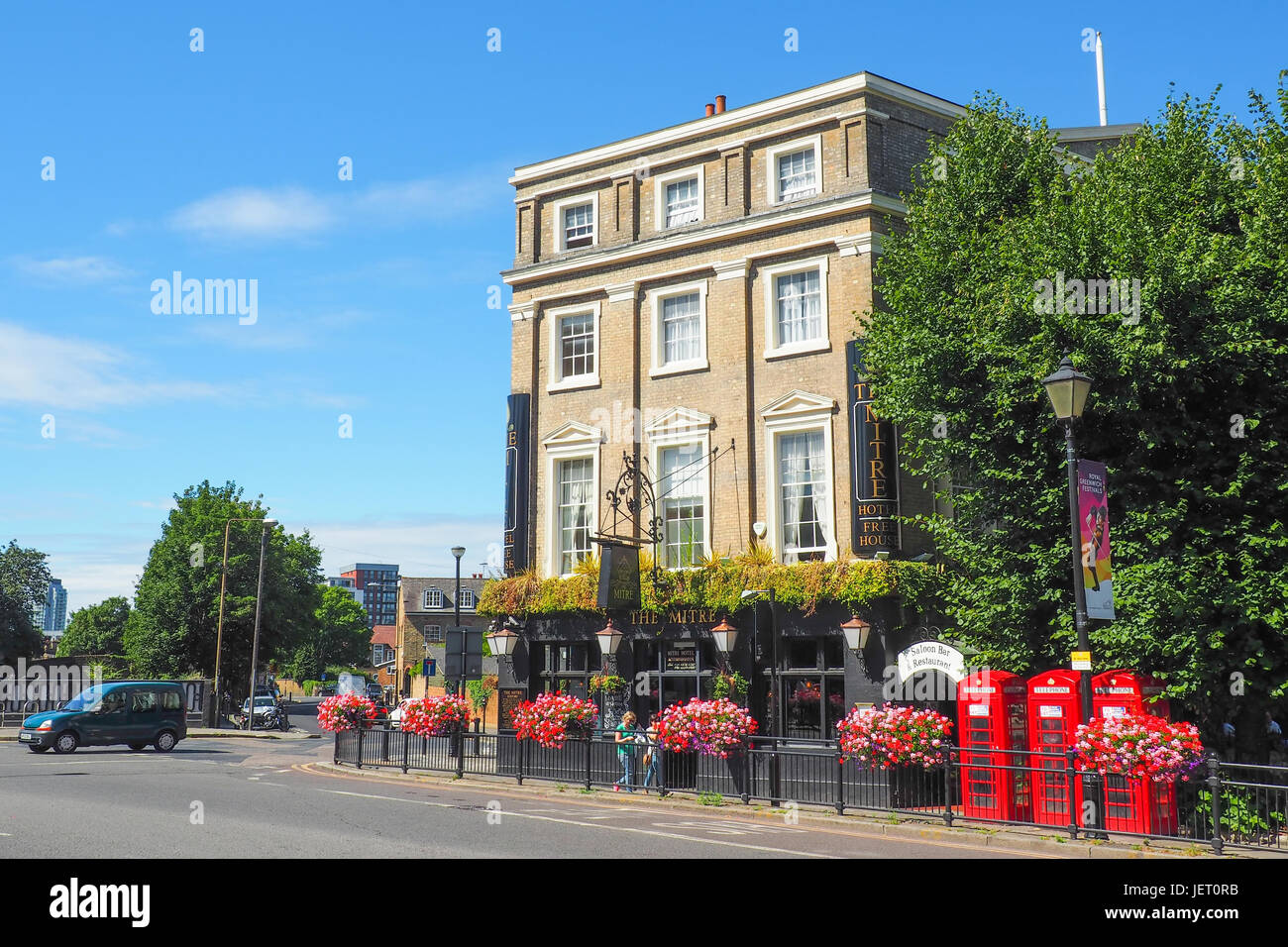 Blick auf die Mitre Hotel und Pub in Greenwich, London in den Sommertag mit unbekannten Menschen vorbei und der rote Telefonzellen in der Nähe. Stockfoto