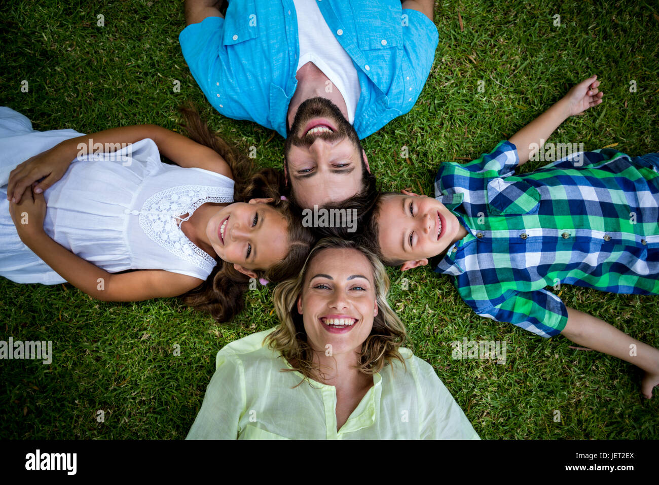 Glückliche Familie liegen auf dem Rasen im Garten Stockfoto