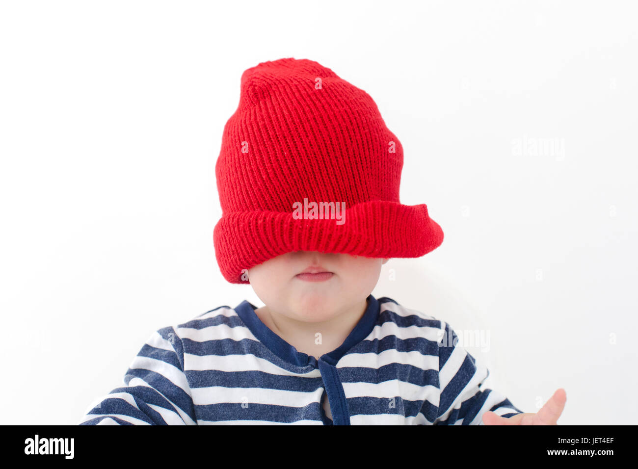 Baby in einem Red Hat zog über sein Gesicht studio Stockfoto