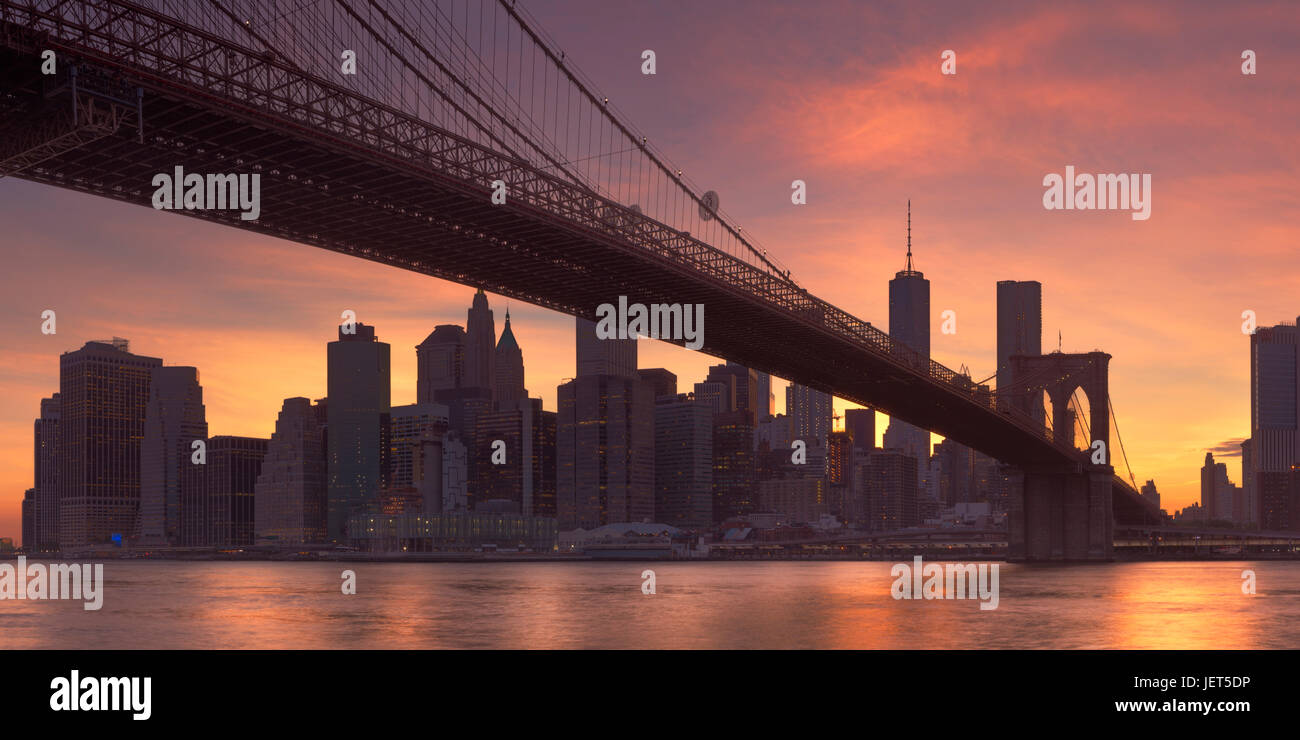 Brooklyn Bridge mit der New Yorker Skyline im Hintergrund, bei Sonnenuntergang fotografiert. Stockfoto