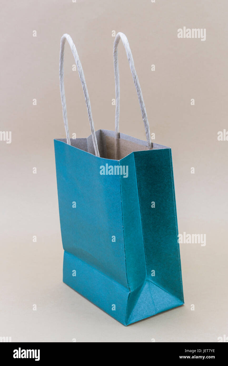 Papier blau Einkaufstasche auf braunem Hintergrund isoliert Stockfoto