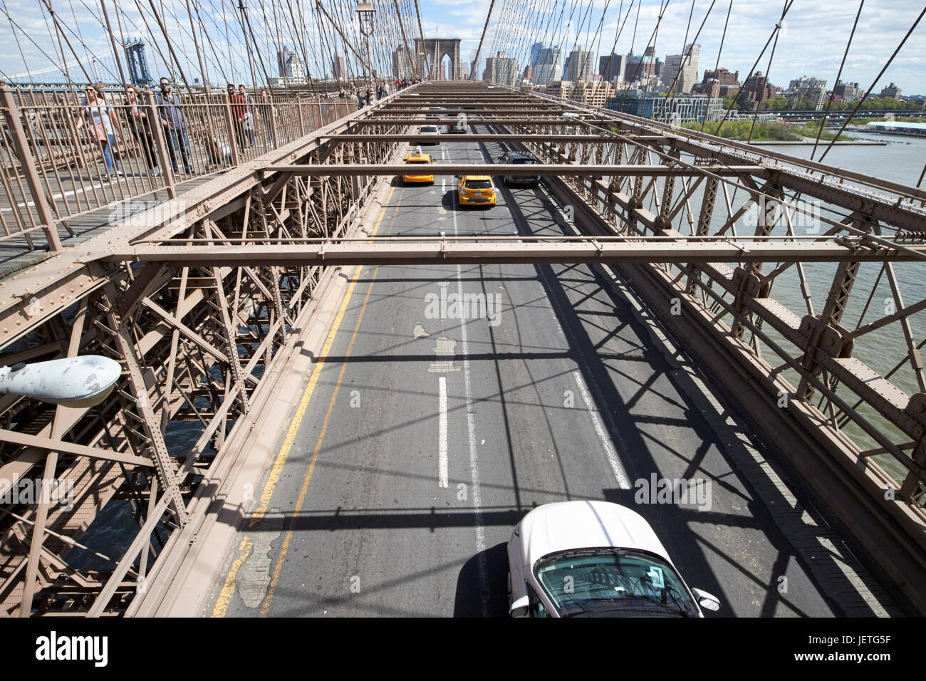 Verkehr Fahrzeuge fahren über die verschlissene Asphalt auf Brooklyn Brücke New York City USA Stockfoto