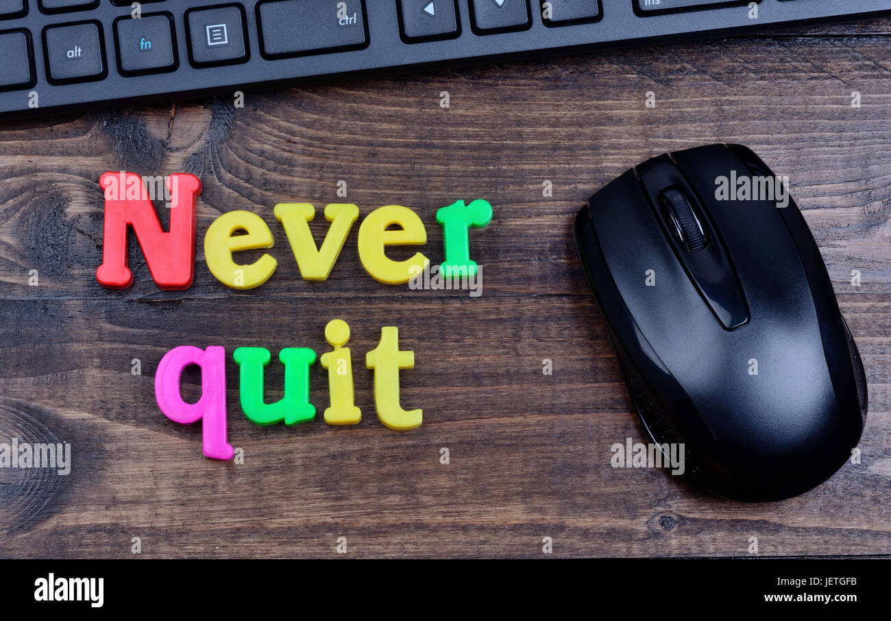 Nie aufhören Sie Wörter auf Holztisch Stockfoto