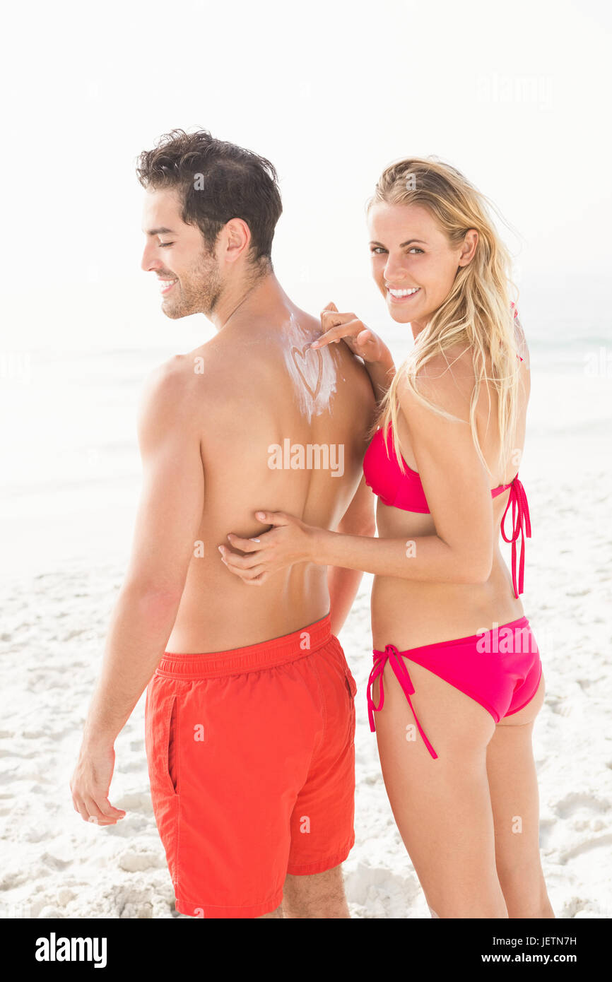 Auftragen von Sonnencreme auf Freund Freundin Stockfoto