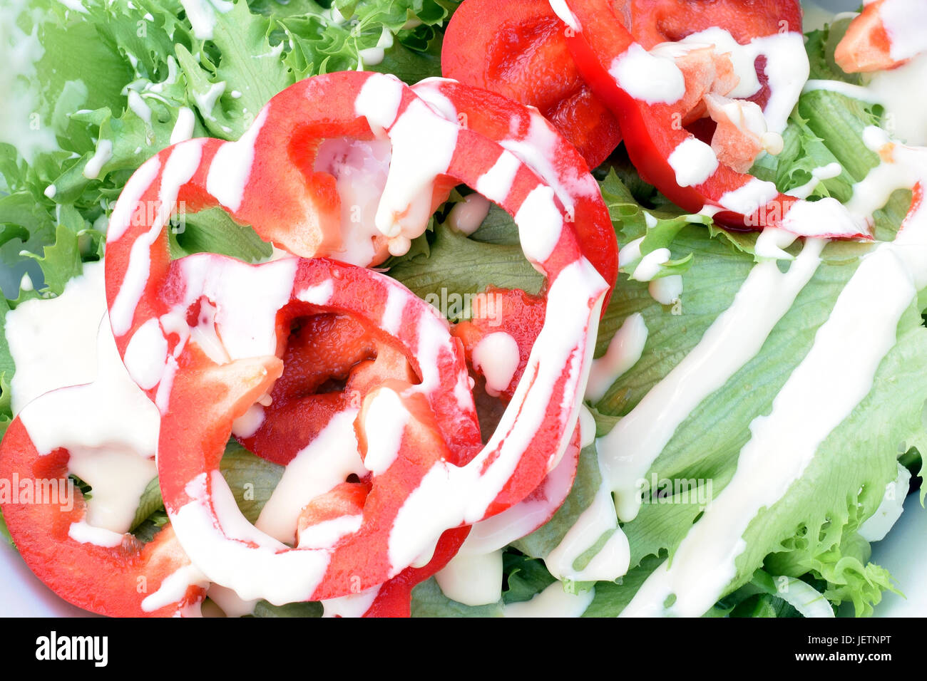 Nahaufnahme von Salat mit Paprika und Salat-Dressing. Stockfoto