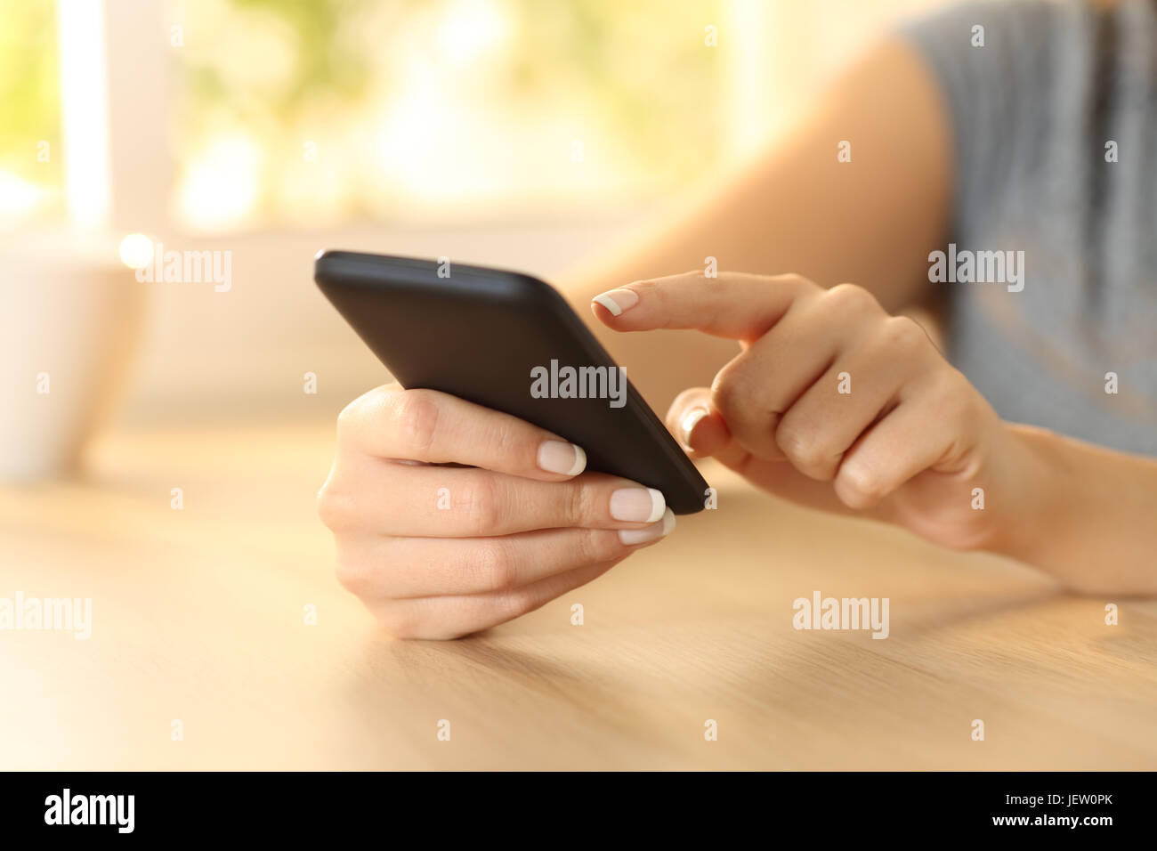 Nahaufnahme einer Frau Hand auswählen von Inhalten auf einem Smartphone in einer Tabelle Stockfoto