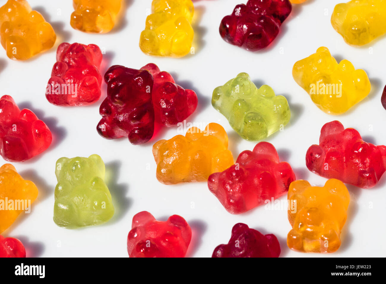 Detail der Gruppe von Gummibärchen auf dem Boden liegend, mit einer Ausnahme, der steht, mit isolierten Hintergrund Stockfoto