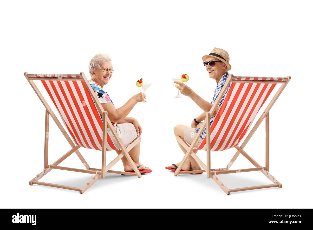 Ältere Touristen mit Cocktails sitzen in Liegestühlen und Blick auf die Kamera isoliert auf weißem Hintergrund Stockfoto