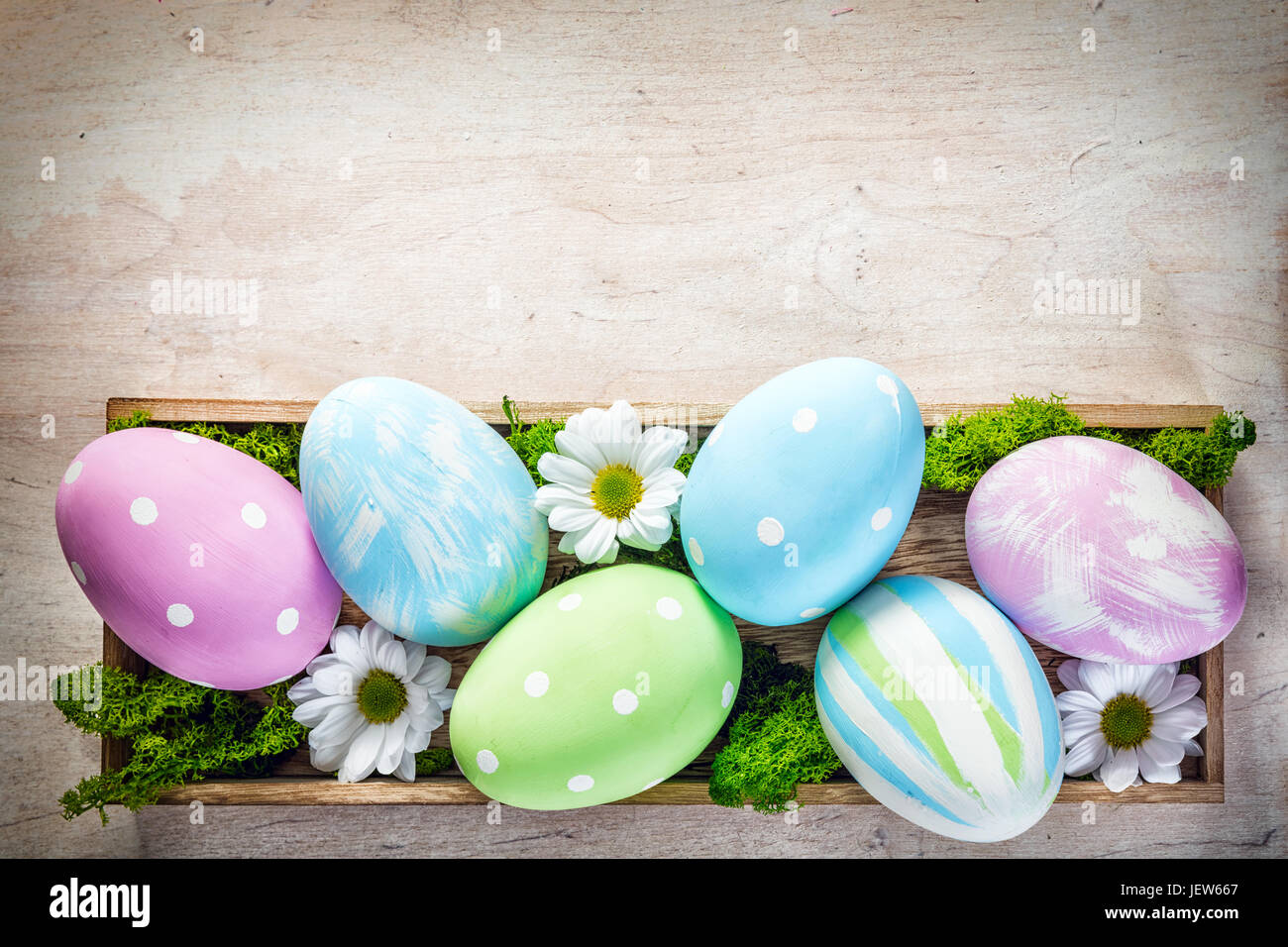 Oster-Deko - Eiern und Blumen auf einem Holz. Urlaubszeit Stockfoto