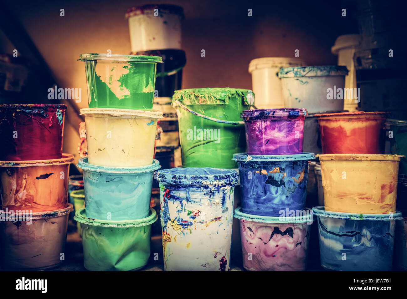 Eimer der flüssigen Farbe stehen in einer Werkstatt. Vintage-Farben Stockfoto