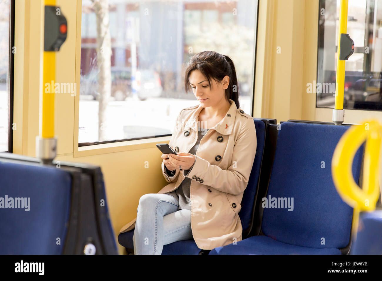 Frau mit Handy in der Straßenbahn Stockfoto