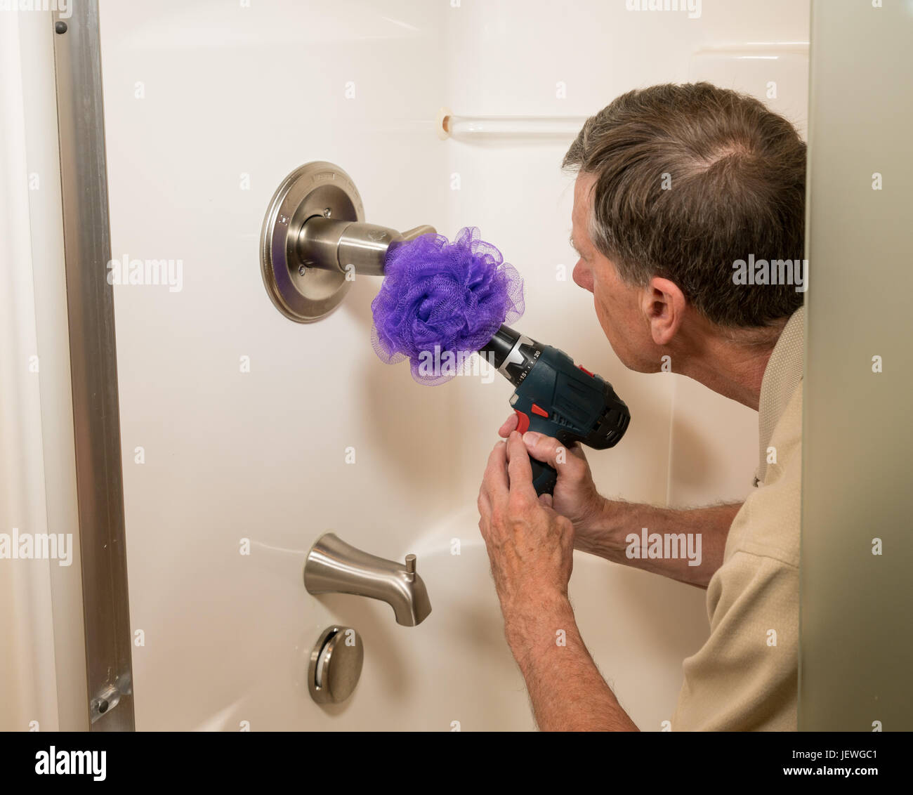 Senior woman Reinigung eine Dusche mit Bohrmaschine Stockfoto