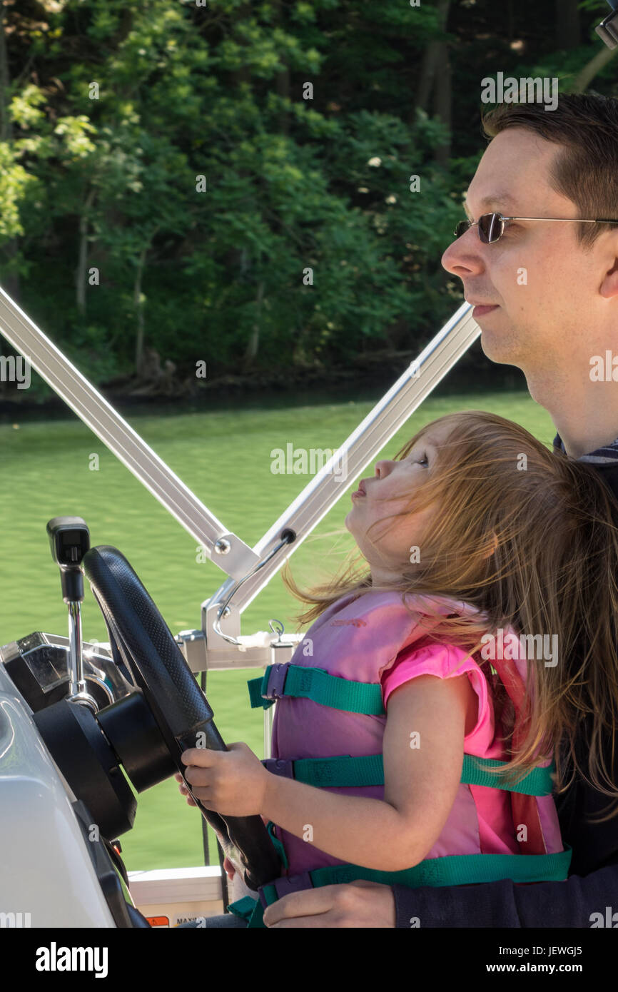 Junge baby Mädchen oder Kleinkind driving Speed-Boot mit Vater Stockfoto