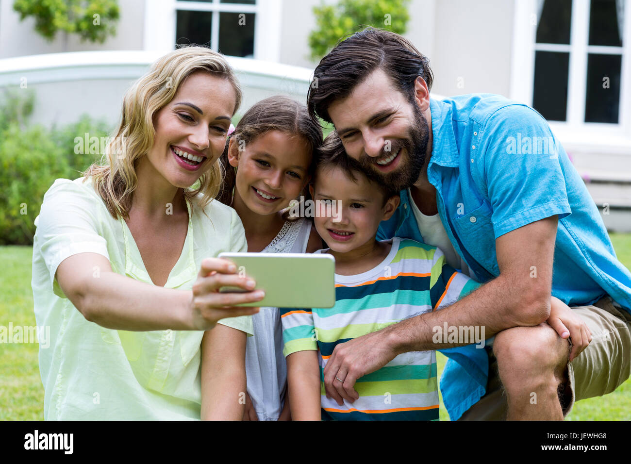 Mutter nehmen Selfie mit Familie in Hof Stockfoto
