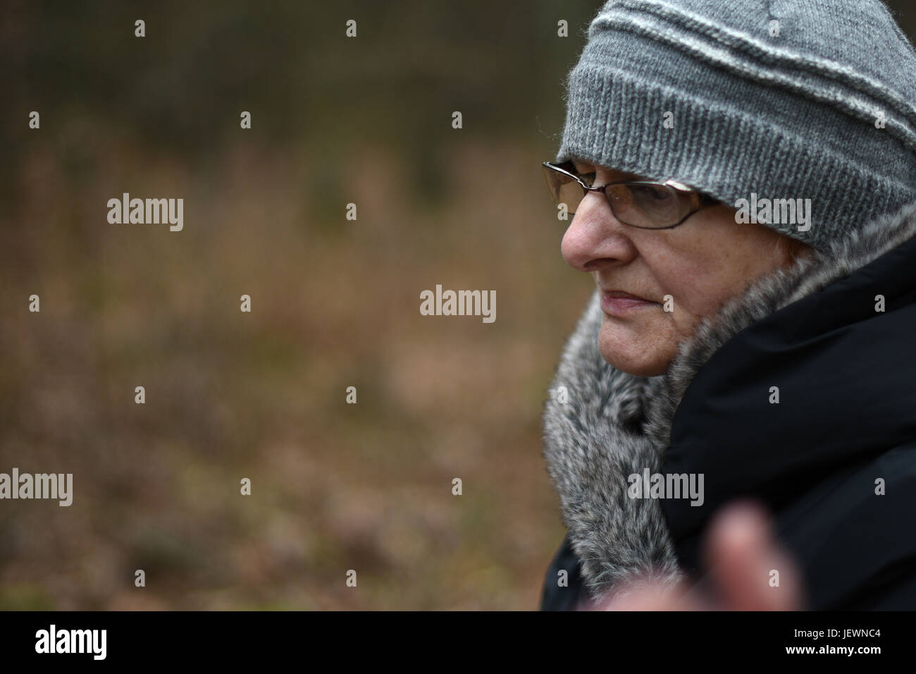 Sad ältere Frau mit Brille schaut vorbei. Stockfoto