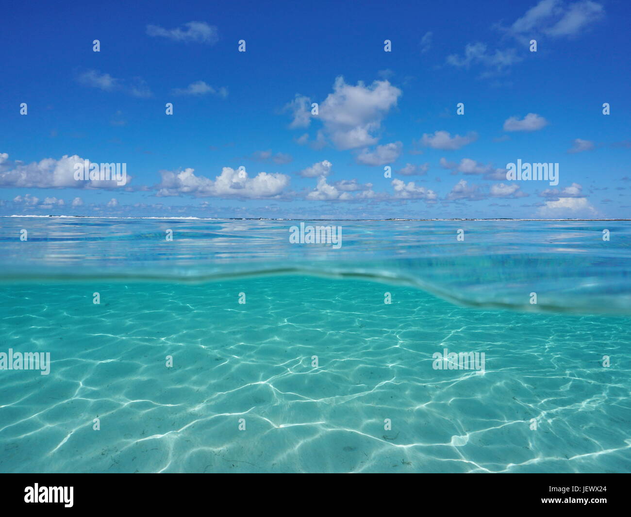 Seascape über und unter der Meeresoberfläche, tropische Lagune mit blauen Wolkenhimmel und unter Wasser eine flachere sandige Meeresboden durch Wasserlinie, Pazifischen Ozean getrennt Stockfoto