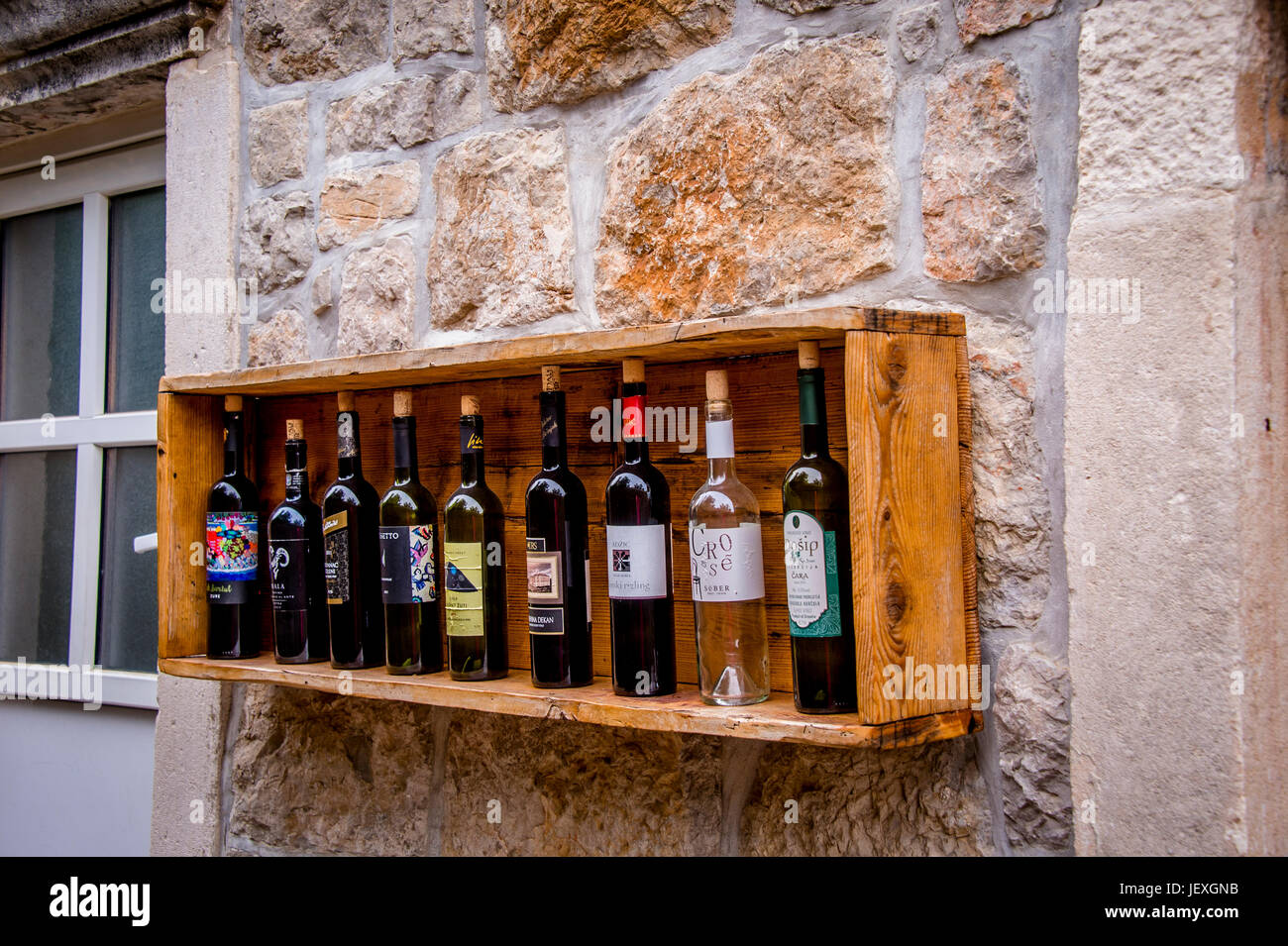Weinflaschen schmücken eine Steinmauer in der Stadt Sudurad auf der schönen Insel Šipan, Kroatien Stockfoto