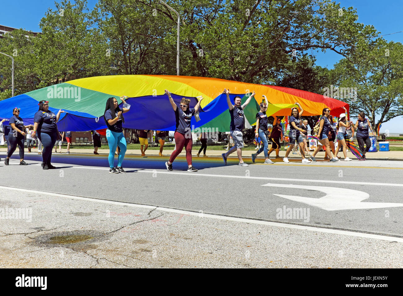 Junge Menschen tragen eine übergroße Regenbogenflagge Lakeside Avenue in Cleveland, Ohio während der jährliche LGBT Pride Parade am 24. Juni 2017. Stockfoto