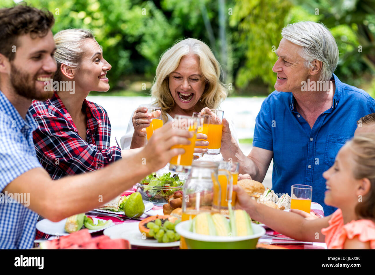 Lächelnd Familie toasten Saft am Tisch Stockfoto