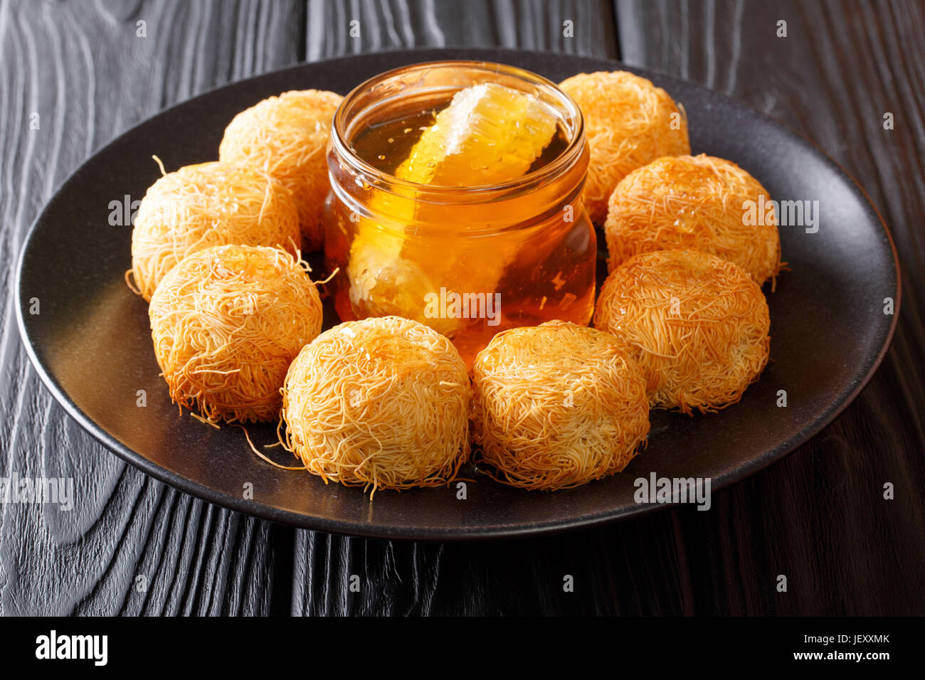 Traditionelle orientalische Süßspeise Kataifi mit Honig Nahaufnahme auf einer Platte. horizontale Stockfoto