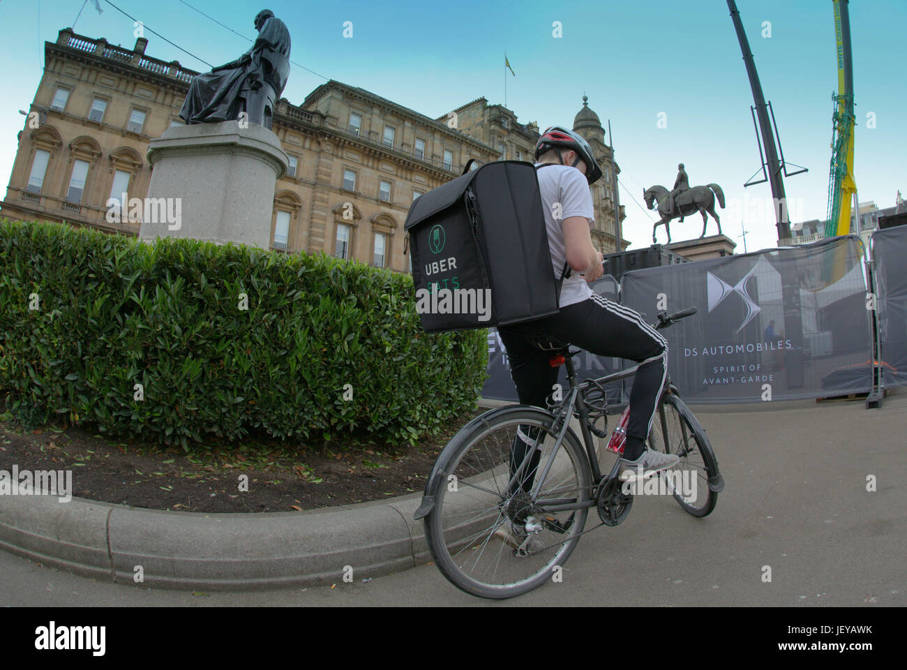 junger Mann Junge Lieferung Fahrrad Radfahrer Uber Essen Lieferung SMS Job glücklich lächelnd warten warten Stockfoto