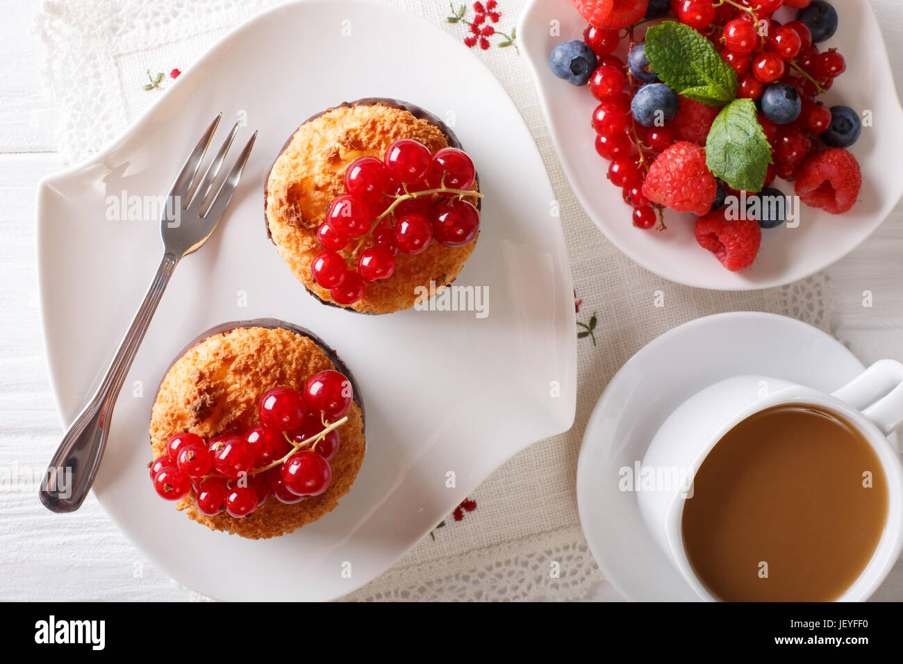 Leckeres Frühstück, Kokos Muffins, Beeren und Kaffee mit Milch Nahaufnahme auf dem Tisch. horizontale Ansicht von oben Stockfoto