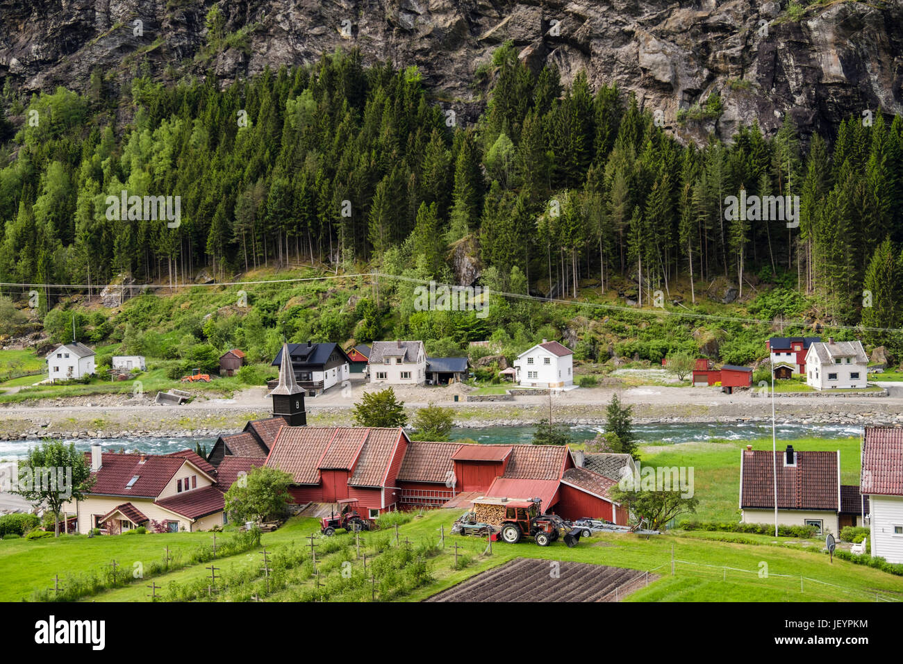 Blick auf alte Dorf am Fluss mit Flam alte Kirche im Flåmsdalen Tal gesehen vom Bahnhof. Flam, Aurland, Norwegen, Skandinavien, Europa Stockfoto