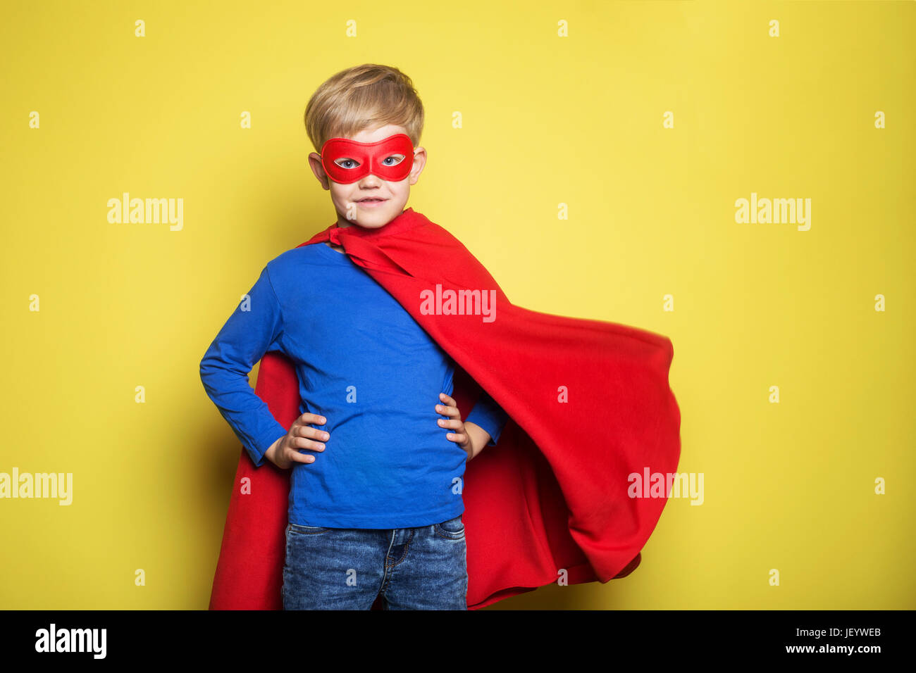 Junge im roten Superhelden Cape und Maske. Superman. Studio-Porträt auf  gelbem Hintergrund Stockfotografie - Alamy