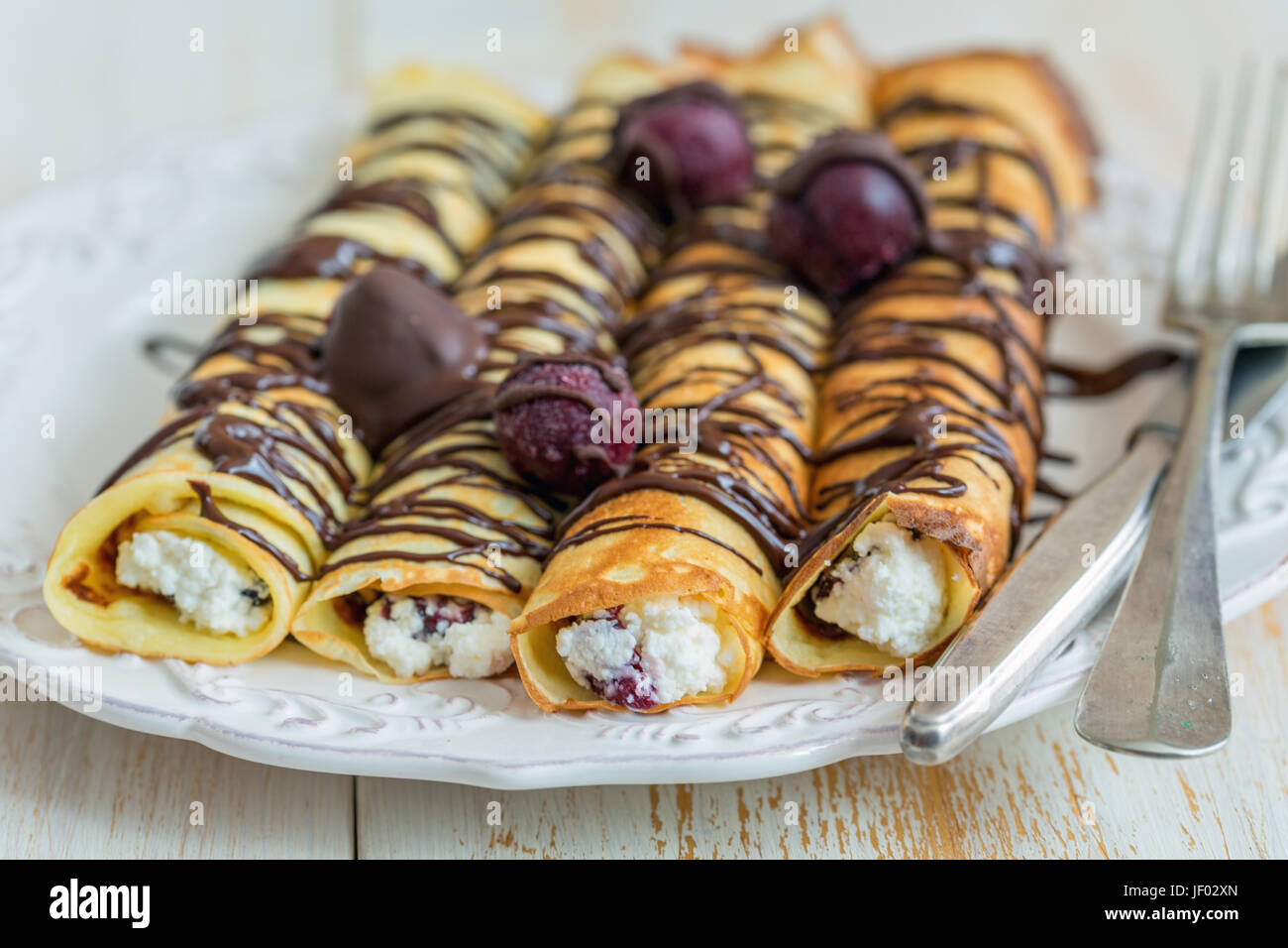 Crepes mit Hüttenkäse und Schokoladensauce. Stockfoto