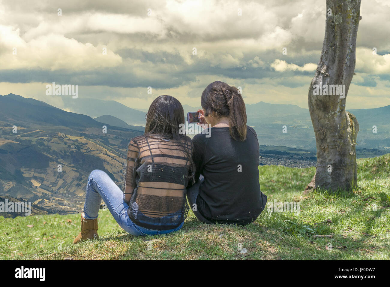 Junge Teens auf Gras sitzen an Höhen Stockfoto