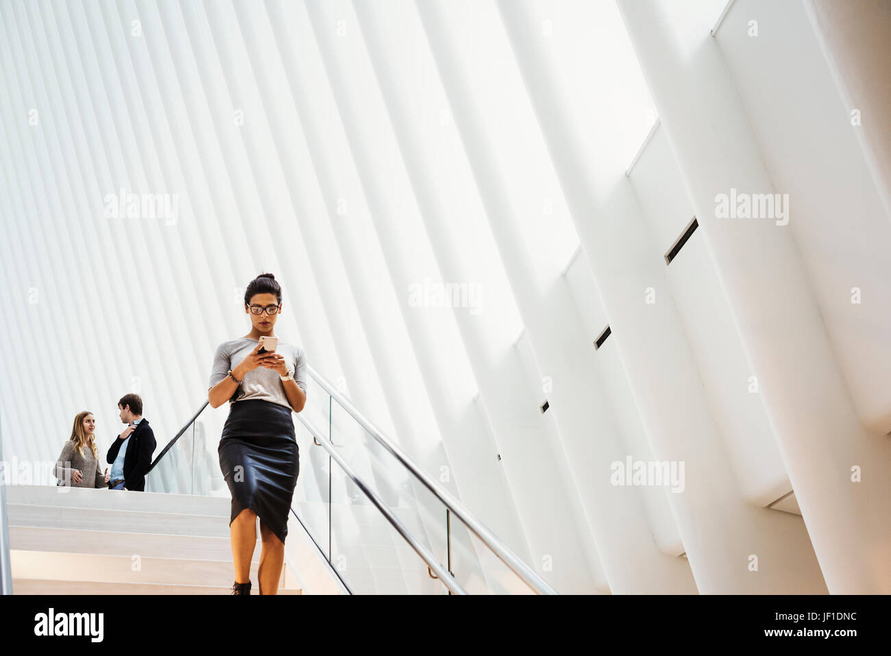 Eine Frau zu Fuß über eine Treppe im Oculus Gebäude, dem World Trade Center Hub, gewölbte moderne architektonische Gestaltung mit einem gerippten Dach-Raum. Stockfoto