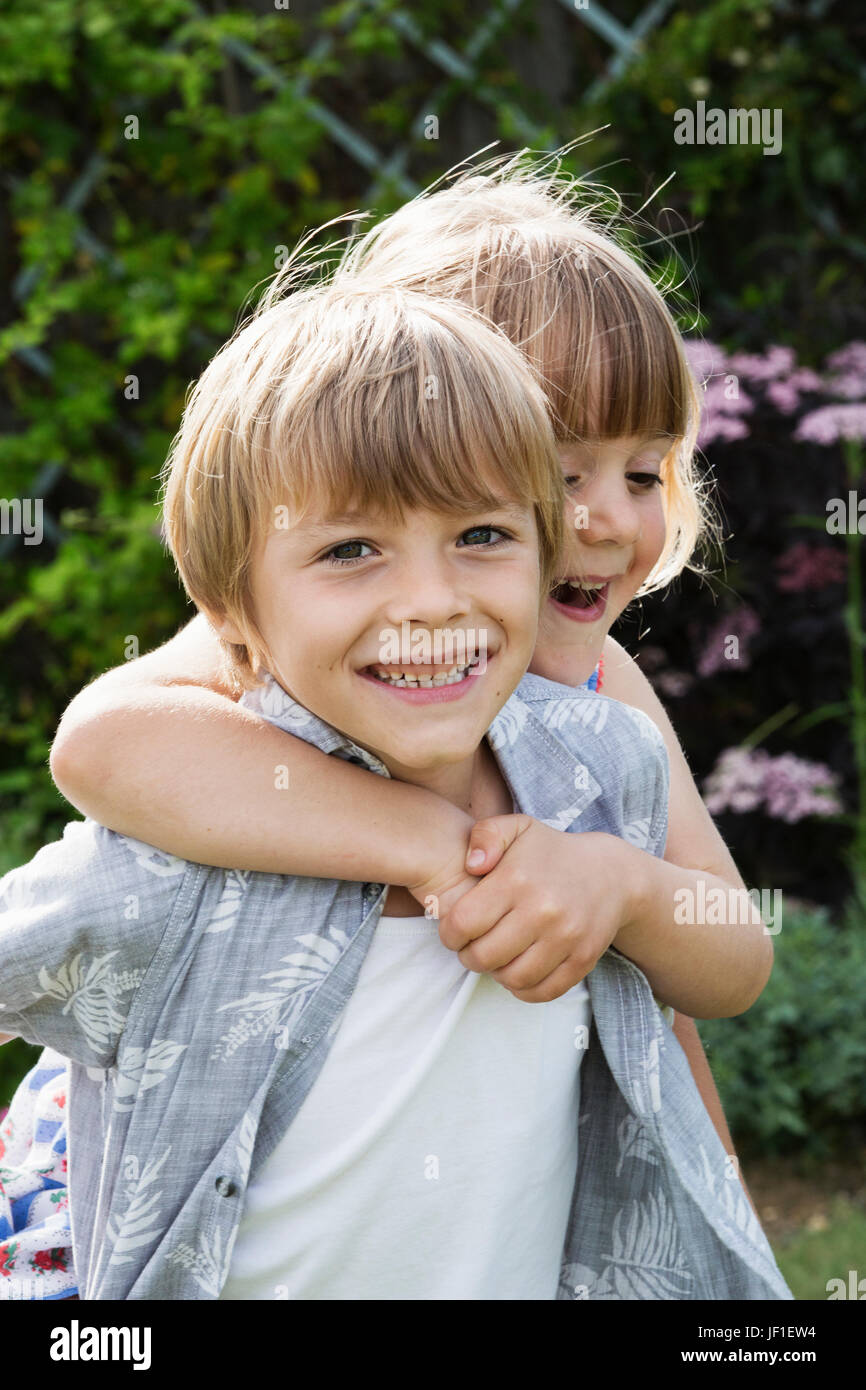 Mädchen umarmt einen lächelnden jungen, Blick in die Kamera. Stockfoto